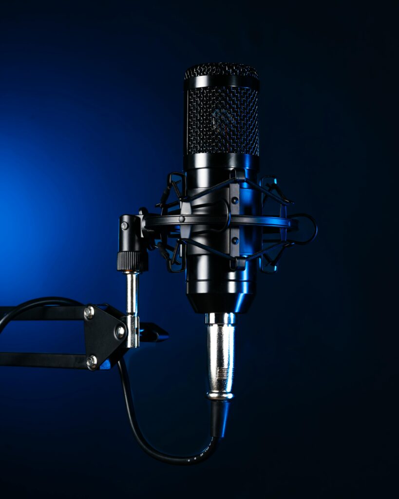 Studio microphone on an adjustable arm with dramatic blue lighting.
